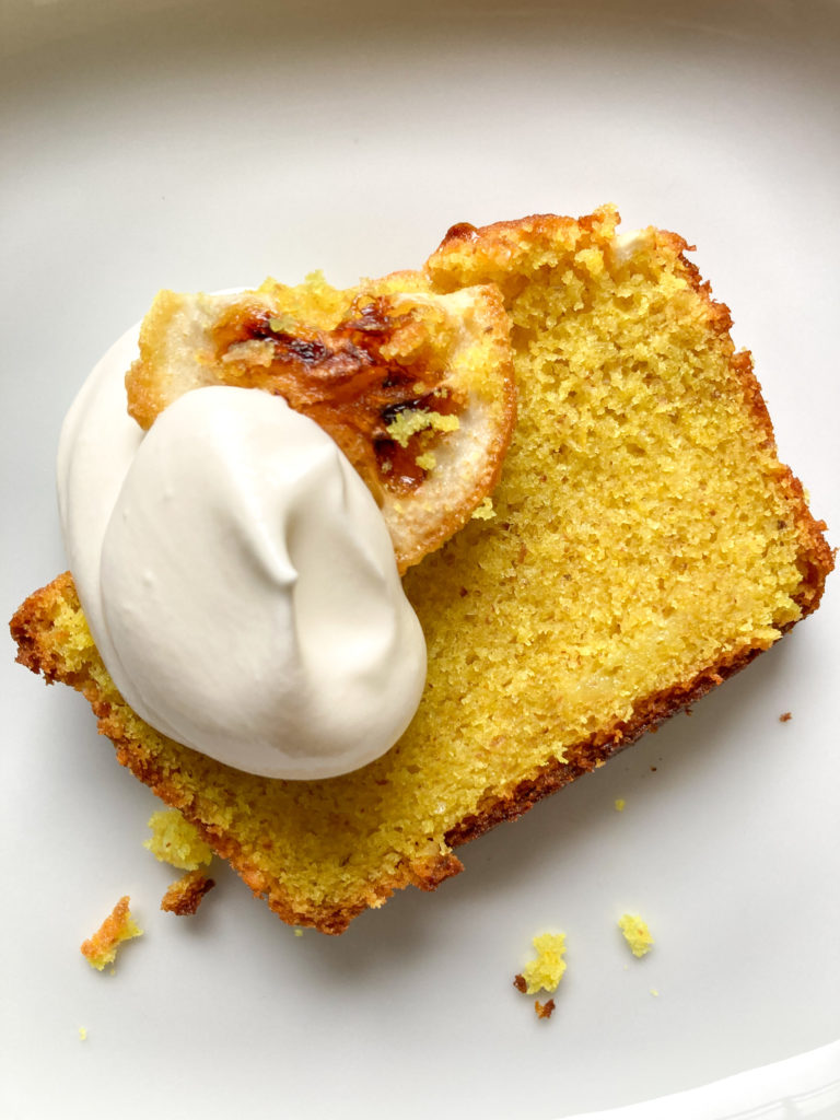 Slice of lemon loaf cake with caramelized lemon and dollop of whipped cream