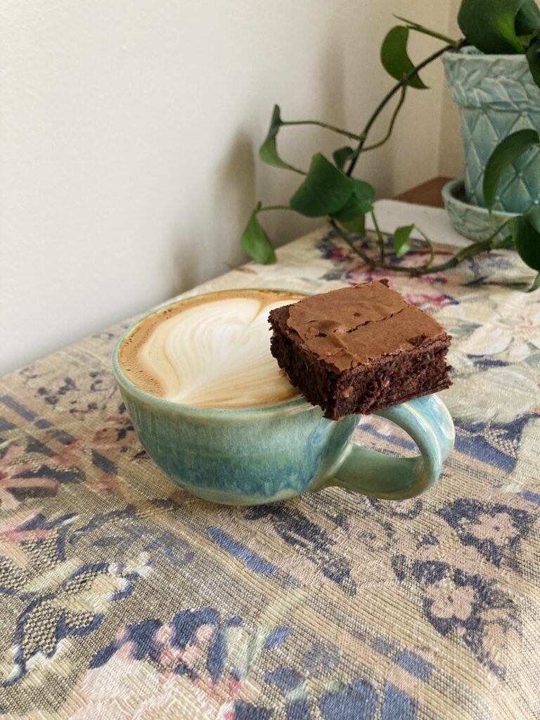 Brownies with a latte in a green mug